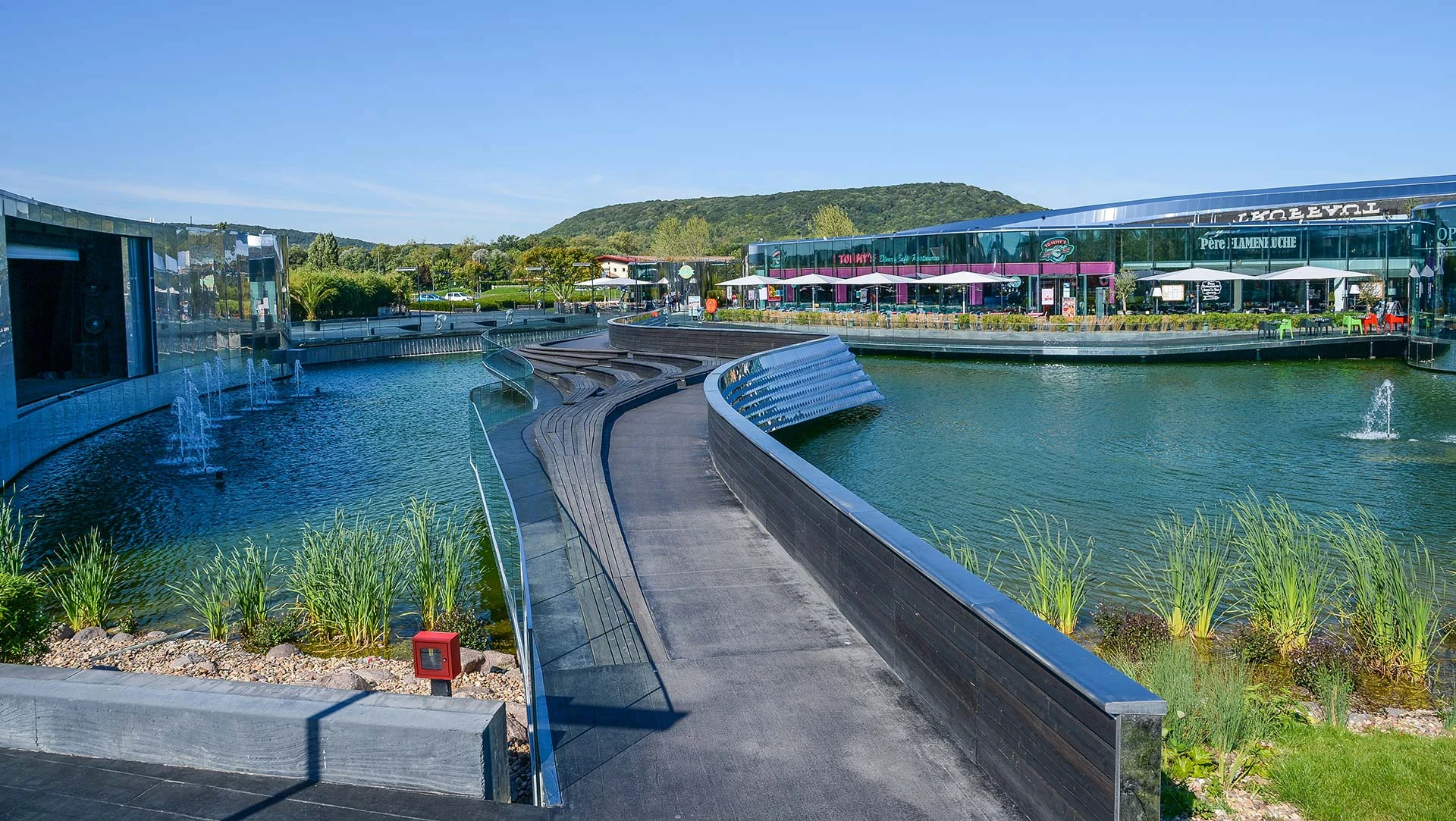 Curved stainless steel wave facade at sunset